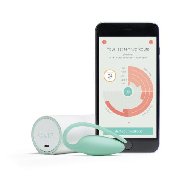 Un smartphone muestra una app de progreso de entrenamiento junto a un dispositivo Elvie verde y blanco con su estuche de carga. Diseñado para ejercicios de Kegel, el monitor dice "elvie" y la app muestra un gráfico circular de los últimos diez entrenamien